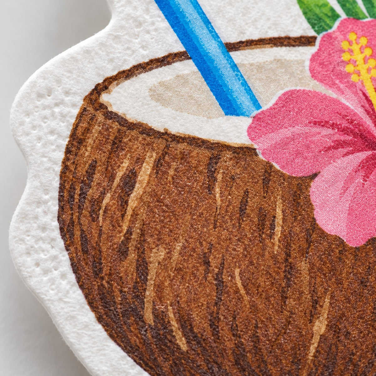A close view shows the matte paper texture and printed coconut artwork on a Hawaiian shaped napkin.
