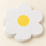 White Daisy Hawaiian shaped paper napkins are stacked on a soft cream studio background.