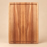 Medium Wooden Kitchen Cutting Board shown alone on a pale warm studio backdrop.