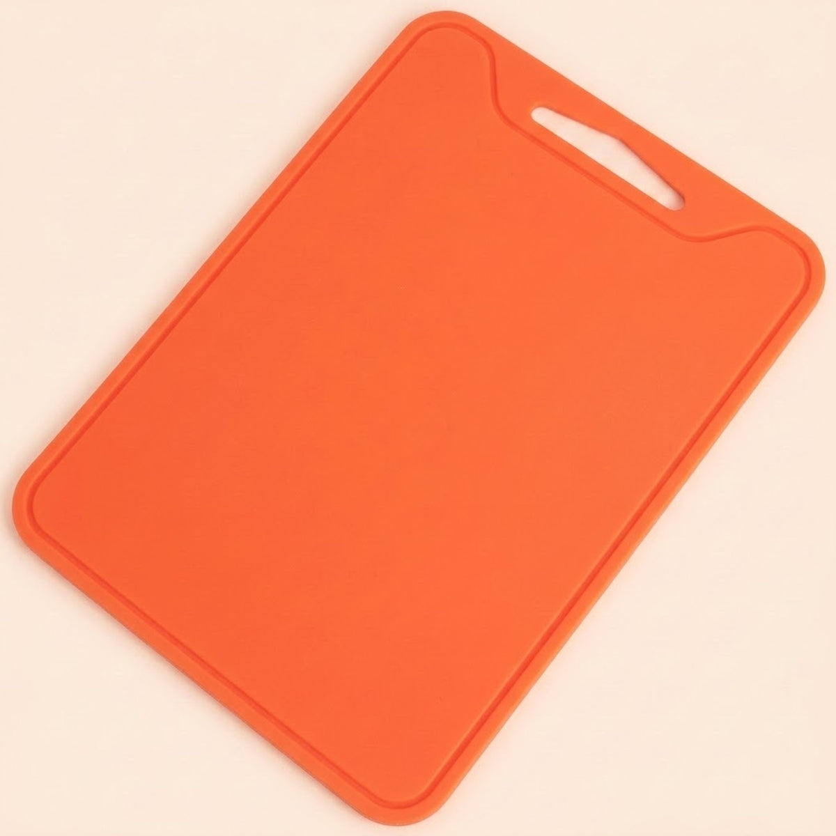 An orange rectangular cutting board with rounded corners and a hanging hole in the top right corner, shown on a light cream background.