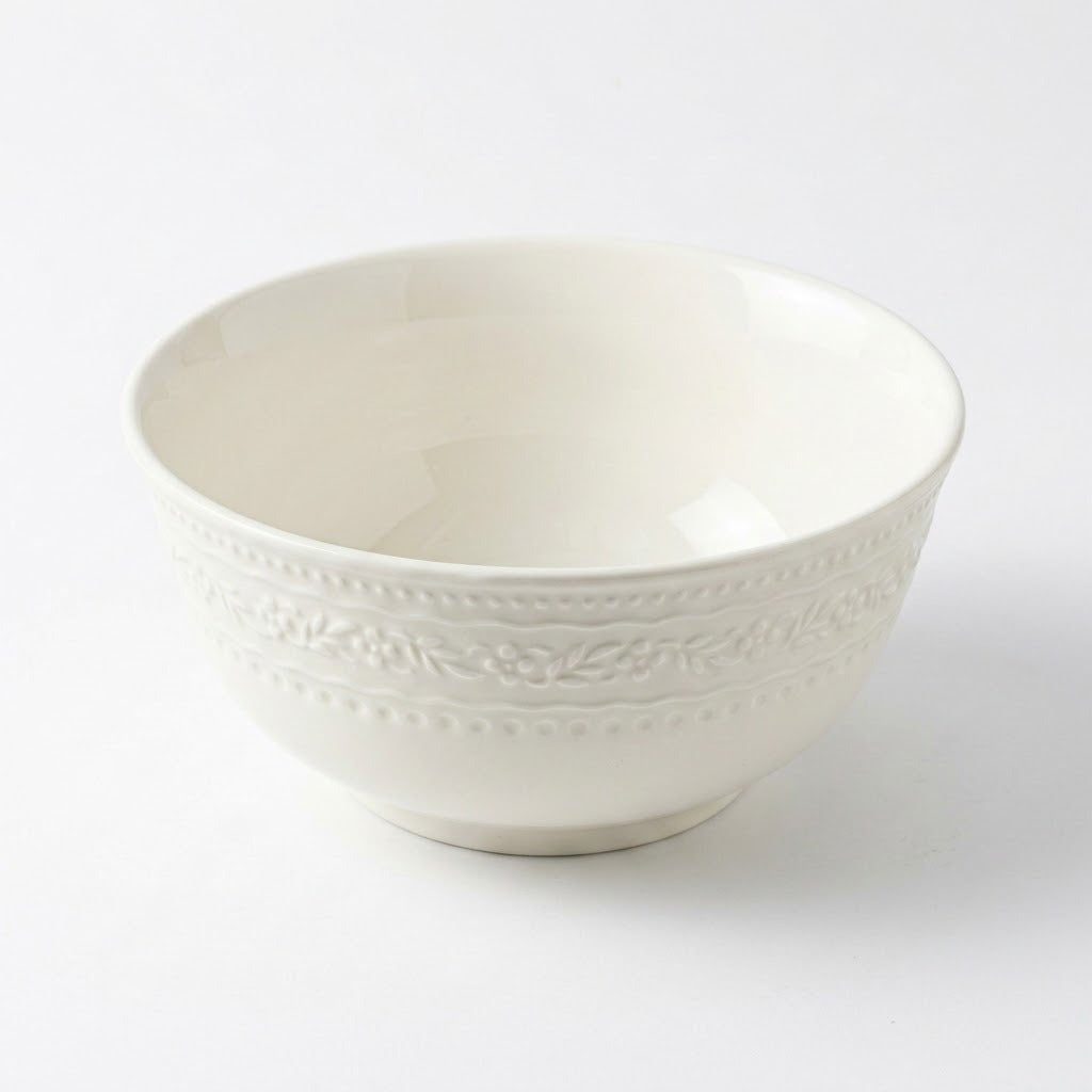 Single white ceramic bowl with embossed decorative bands and a raised foot on a white background.