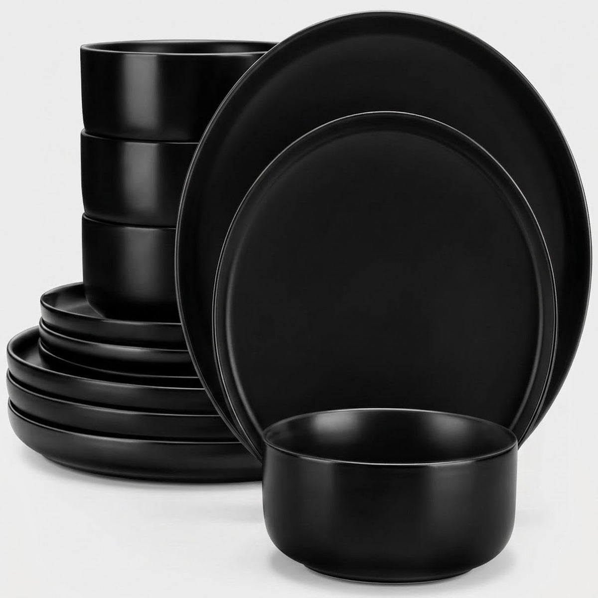 A set of matte black dinnerware, including plates and bowls, arranged on a clean white background.