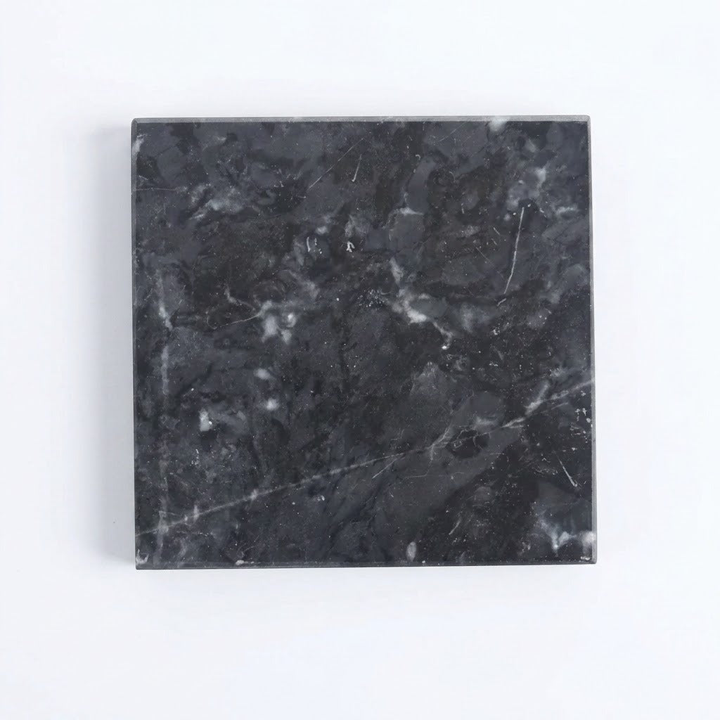 A square black marble tile with white and gray veining, shown from a top-down view on a plain white background.