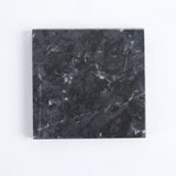 A square black marble tile with white and gray veining, shown from a top-down view on a plain white background.