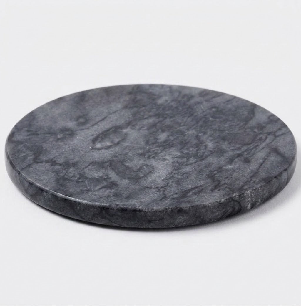 A round dark gray stone coaster with a natural marbled texture, photographed on a clean white background.
