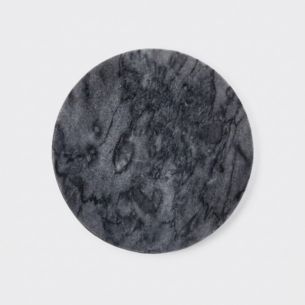 A round black marble coaster with natural veining, shown on a clean white background.