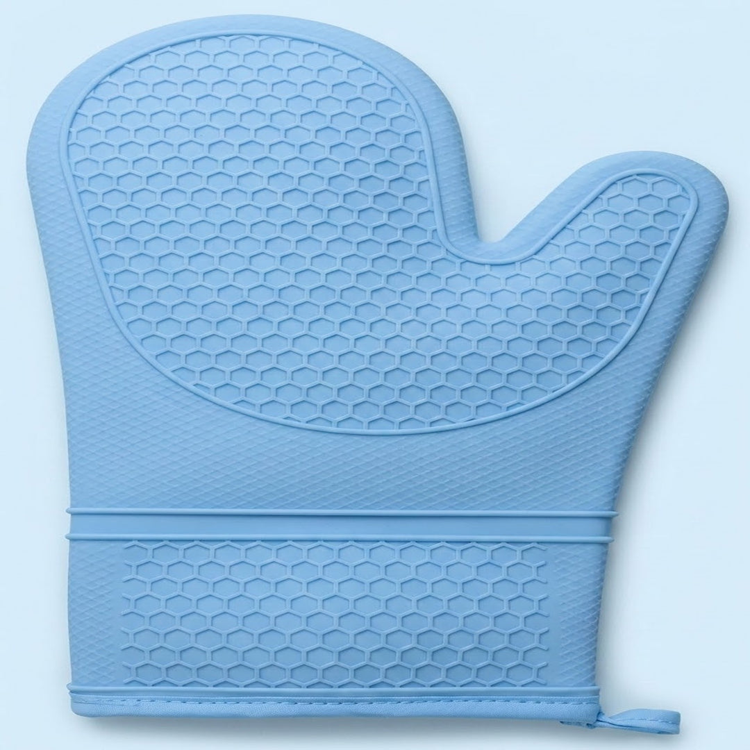 A light blue silicone oven mitt with a raised honeycomb texture, featuring a wrist strap with a small pull tab, shown against a light blue background.