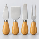 The Silver four-piece wooden handle cheese set is centered against a light silver studio backdrop.