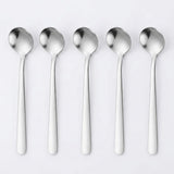 Five stainless steel spoons aligned vertically side-by-side on a clean, light gray background.