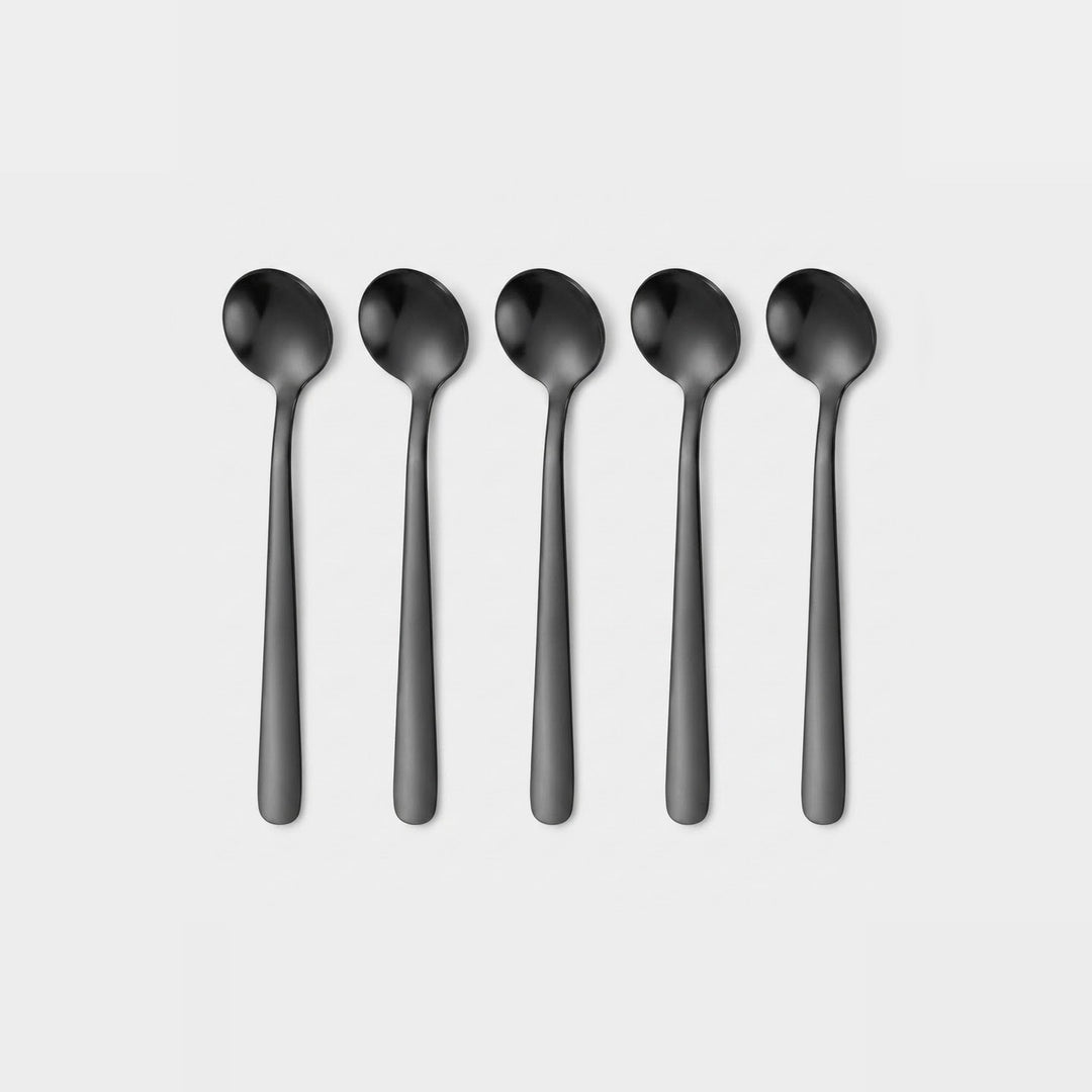 Five matte black spoons arranged in a row on a light gray background.