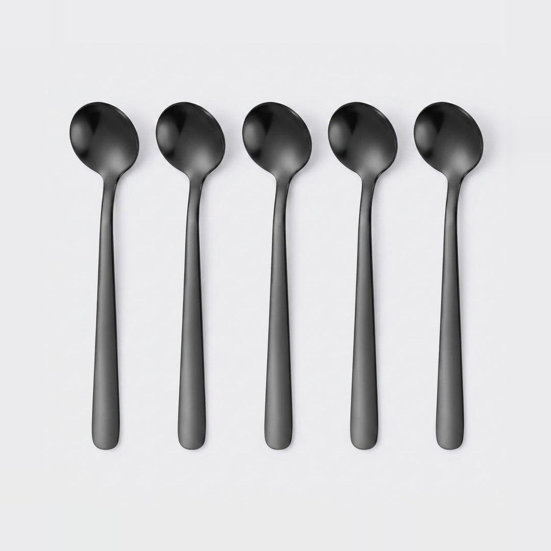 Five matte black spoons arranged in a row on a light gray background.
