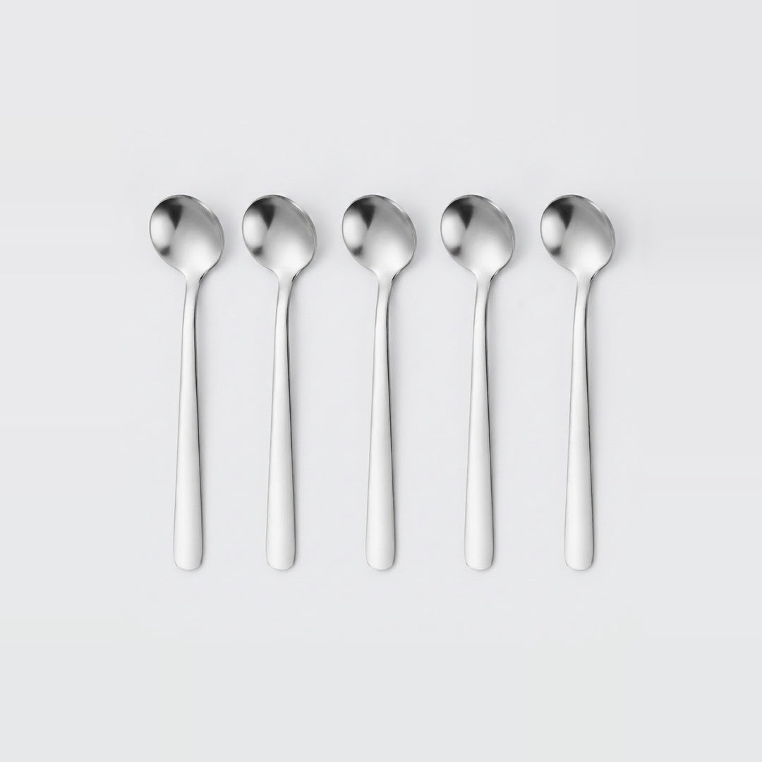 Five identical polished stainless steel spoons aligned in a row on a light gray background.