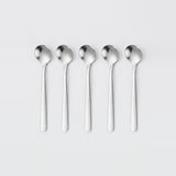 Five identical polished stainless steel spoons aligned in a row on a light gray background.