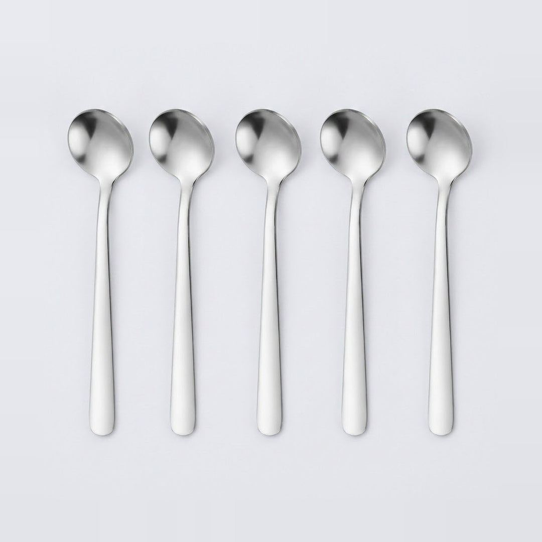Five stainless steel spoons aligned in a row on a light gray background.