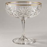 The coupe cocktail glass has a crisp engraved starburst bowl and a fine gold rim.