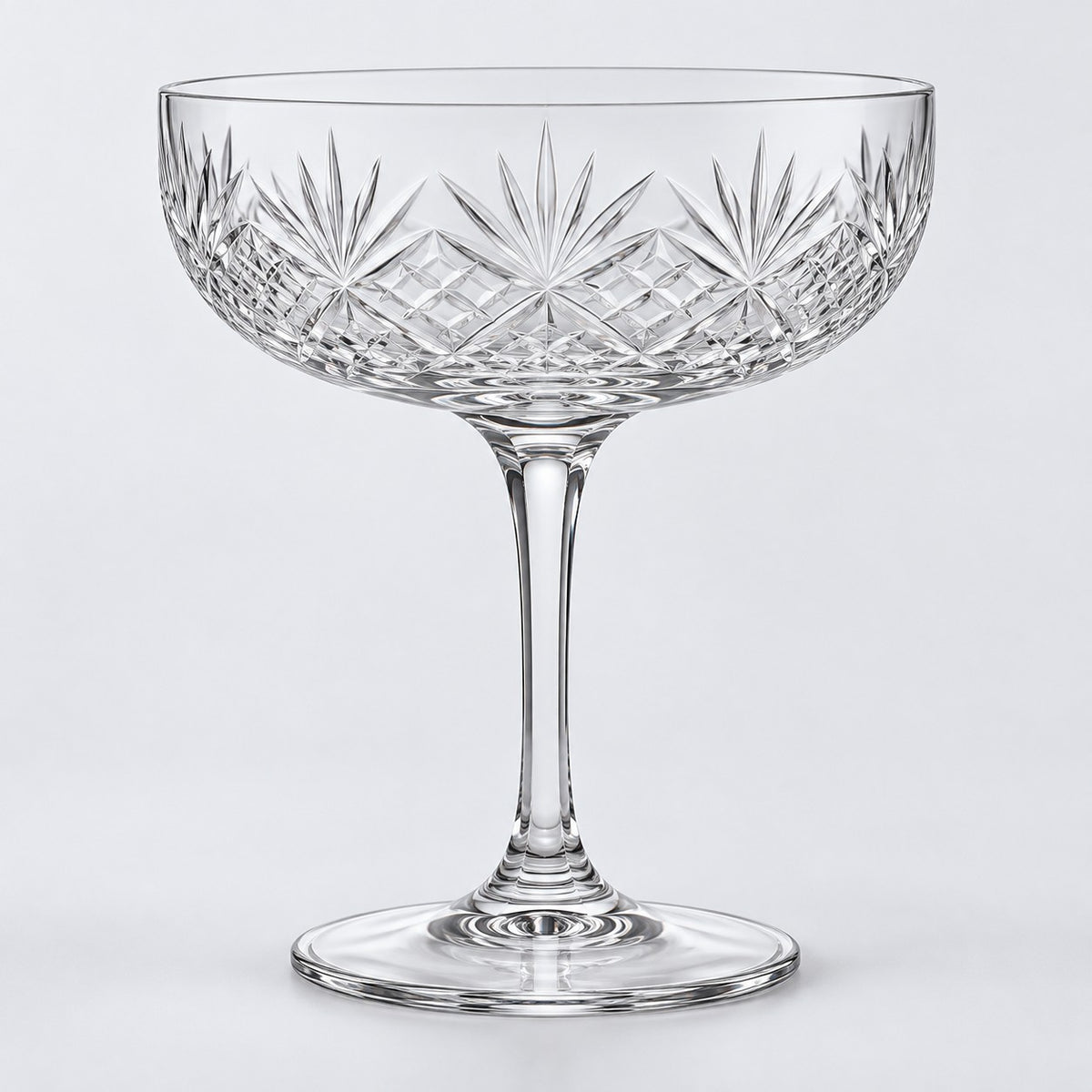 The No Gold Rim coupe cocktail glass shows its clear edge on a pale gray studio background.
