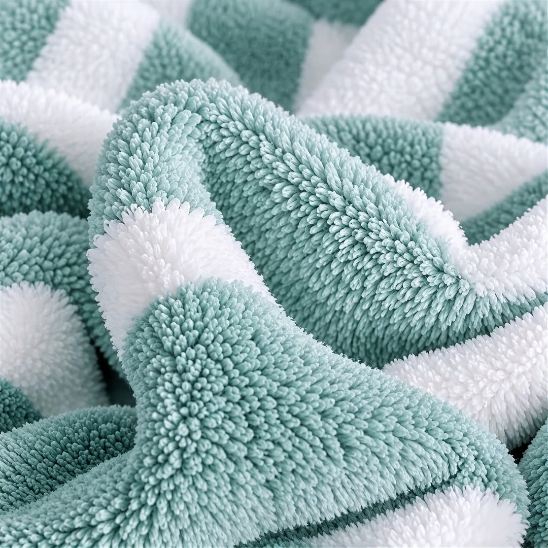 A close-up of loosely gathered mint green and white striped towel fabric shows its dense, fluffy texture.