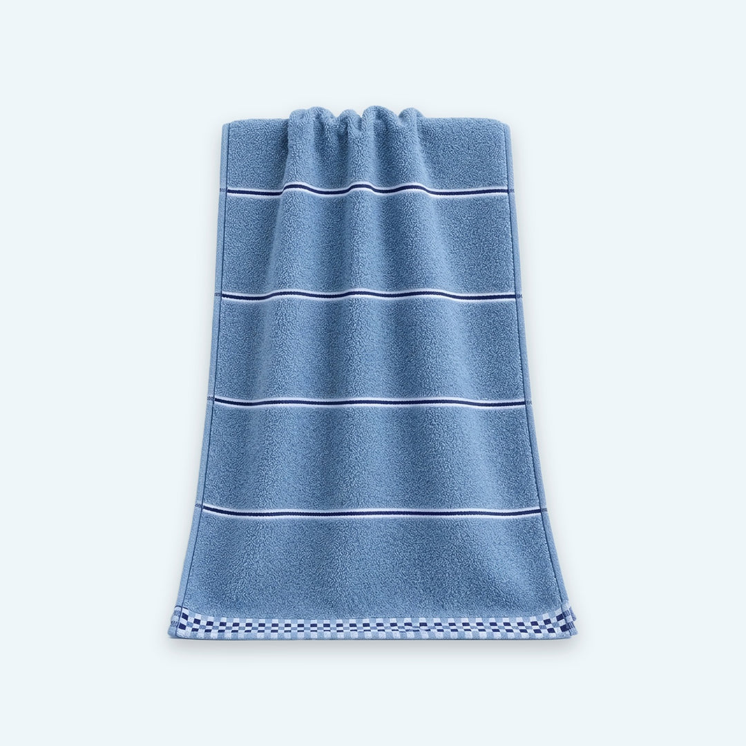 A blue terry towel with thin dark and white stripes and a checkered bottom border drapes against a pale blue background.