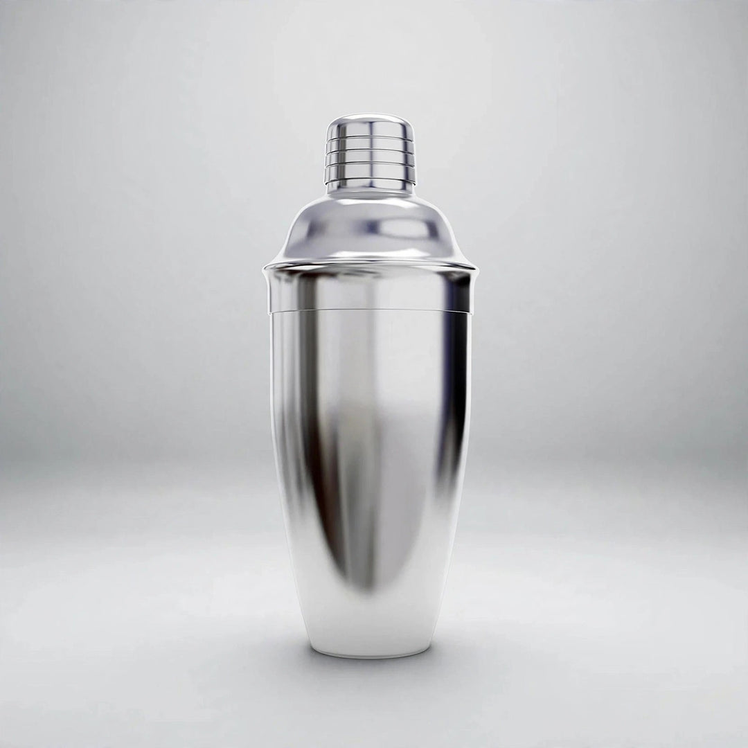 A polished silver cocktail shaker with a domed lid and grooved cap stands upright against a light gray background.