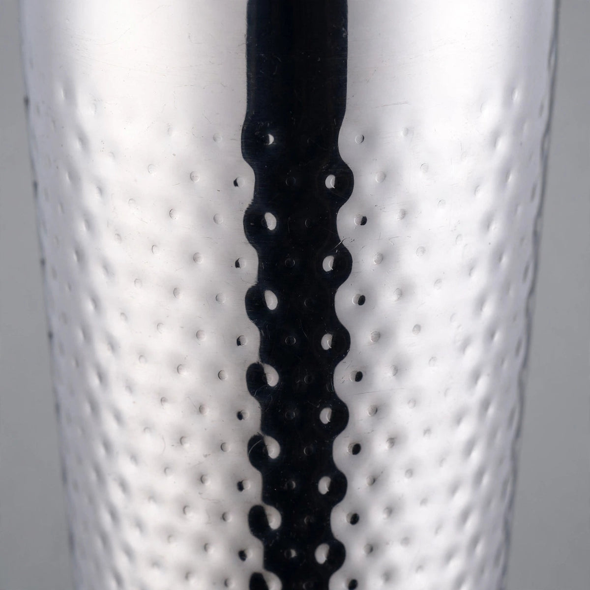 Close-up of the dimpled hammered texture covering the stainless steel body of the cocktail shaker.