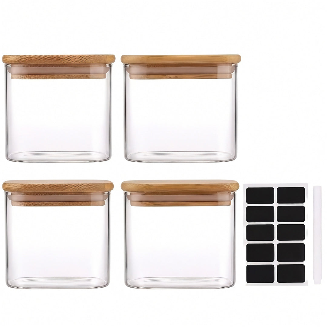 Four clear glass jars with bamboo lids sit beside ten black labels and a white marker against a white background.