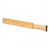 A single natural bamboo drawer divider with an extended slotted section and black end pads rests against a white background.