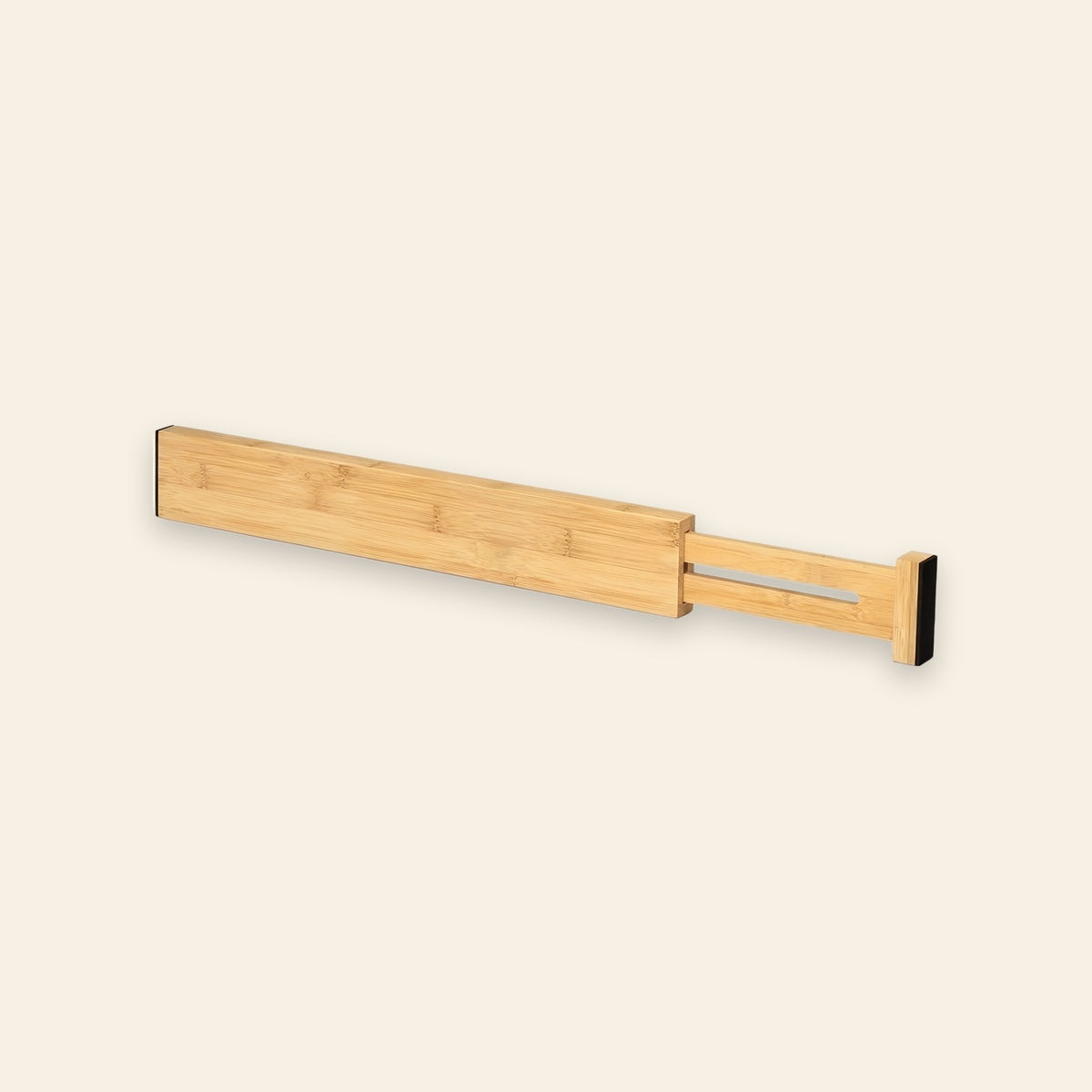 One natural bamboo drawer divider with an extended slotted section and black end pads sits against a cream background.