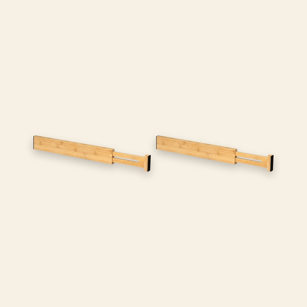Two natural bamboo drawer dividers with extended slotted sections and black end pads sit side by side against a cream background.