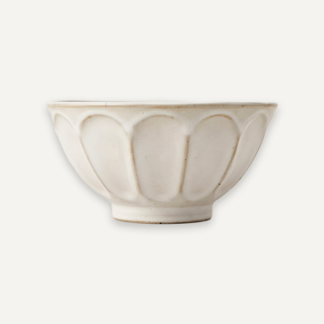 An off-white ceramic bowl with a textured, hand-painted lotus petal design, shown against a solid off-white background.