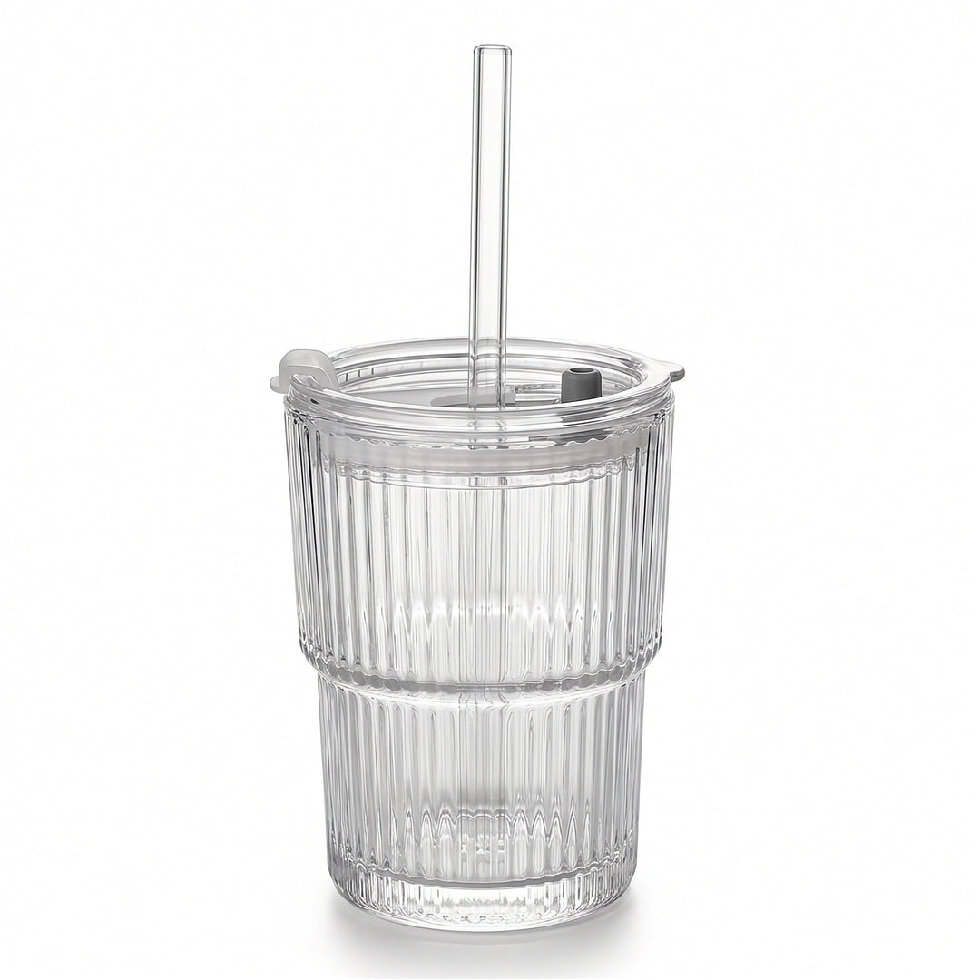 Empty clear ribbed tumbler with a transparent lid, straight straw, and gray lid fitting stands against a white background.