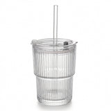 Empty clear ribbed tumbler with a transparent lid, straight straw, and gray lid fitting stands against a white background.