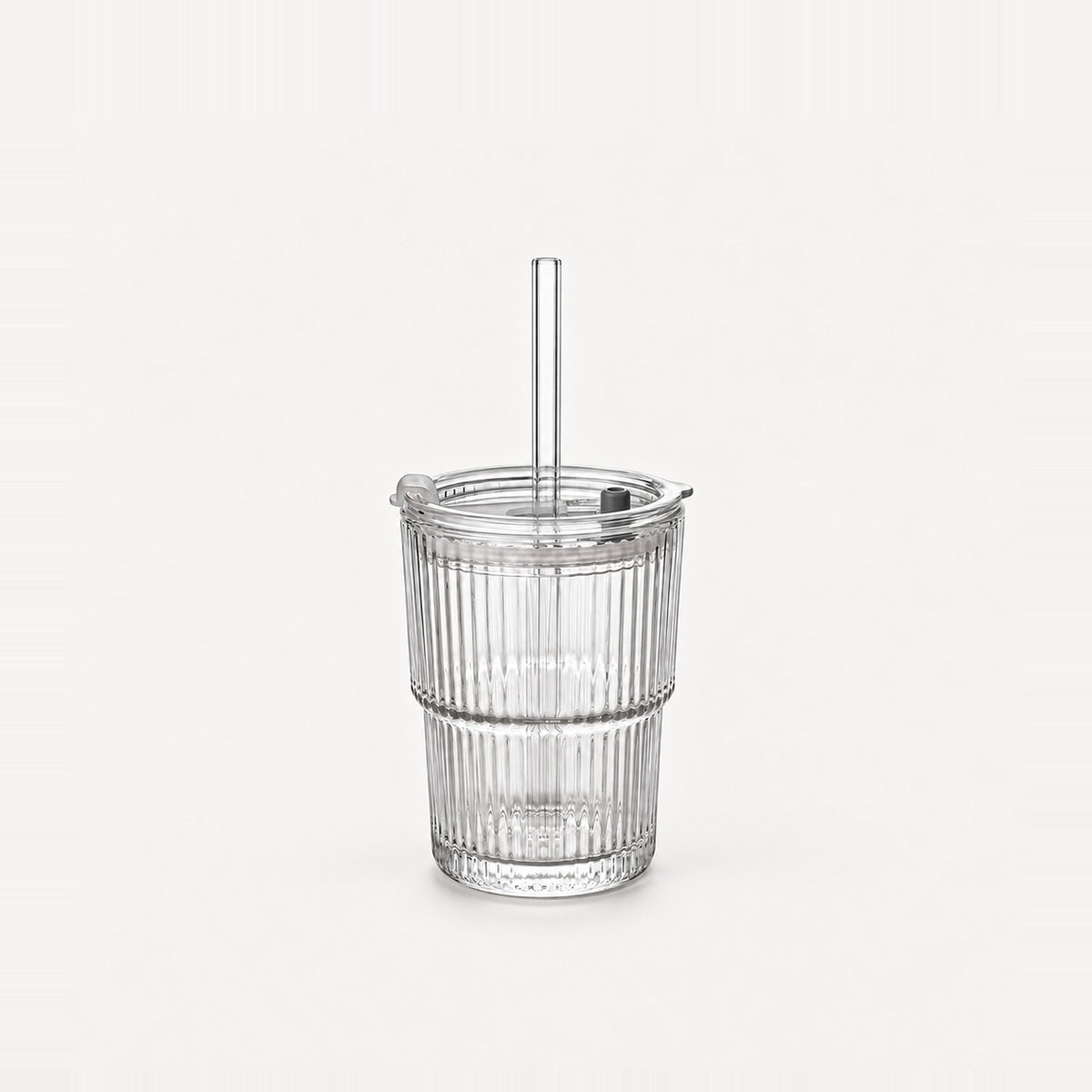 Empty clear ribbed glass tumbler with lid and straight glass straw, 13.5 fl oz (400 ml), on a light warm grey backdrop