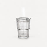 Empty clear ribbed glass tumbler with lid and straight glass straw, 20.3 fl oz (600 ml), on a light warm grey backdrop