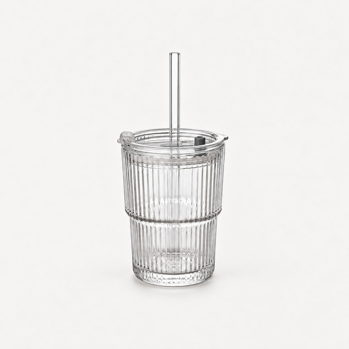 Empty clear ribbed glass tumbler with lid and straight glass straw, 20.3 fl oz (600 ml), on a light warm grey backdrop