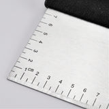 Close-up of the brushed stainless steel blade and etched centimeter ruler of the bench scraper