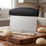 Dough cutter dividing a dough rope into rolls on a wooden cutting board