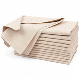 A stack of folded beige fabric napkins or table linens with one napkin draped on top, photographed on a clean white background.