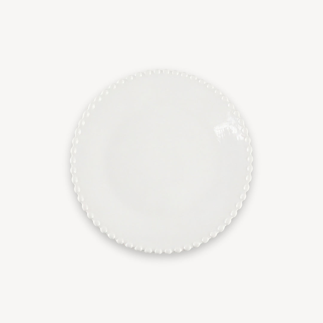 A white round plate with a glossy surface and beaded edge sits centered against a plain white background.