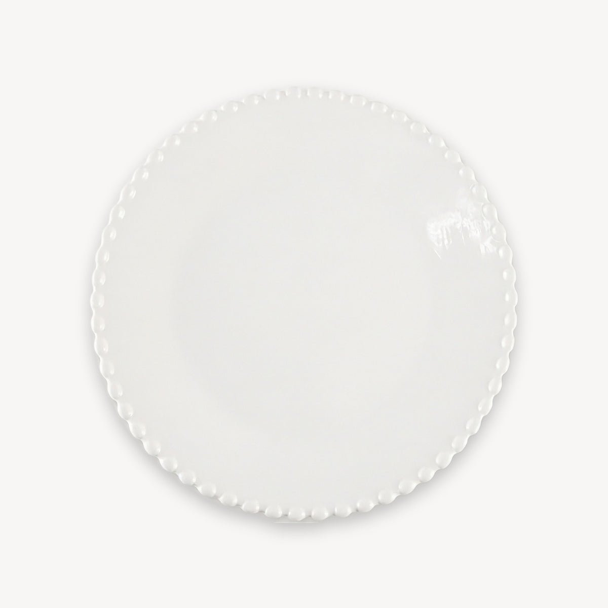 A glossy white round plate with a beaded rim is shown from above against a plain white background.