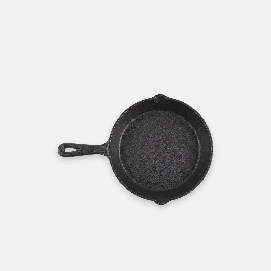 Black bare cast iron skillet, 8 in (20 cm), on a light grey backdrop