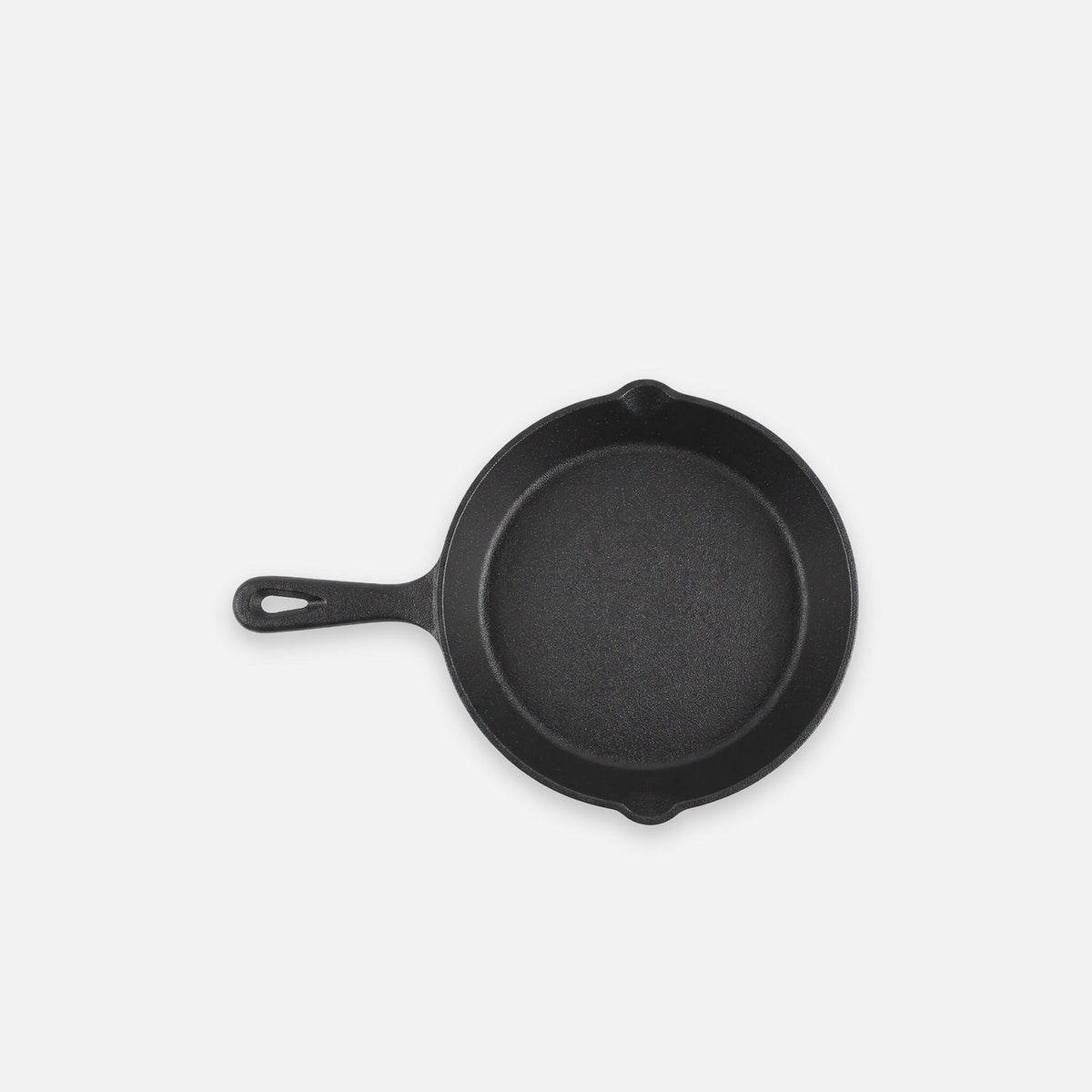 Black bare cast iron skillet, 8 in (20 cm), on a light grey backdrop