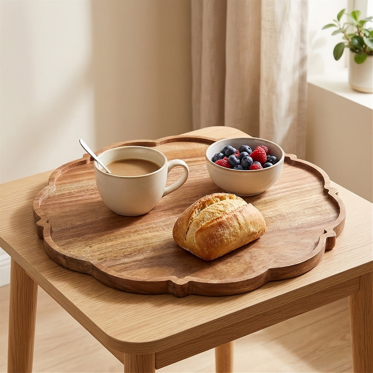 A scalloped wooden serving tray displayed on a light wood table, styled with a cup of coffee, a small bowl of mixed berries, and a croissant in a bright, modern room.