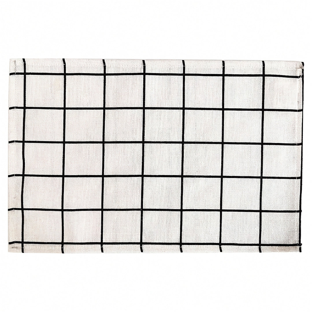 A square white fabric placemat or table runner featuring a black hand-drawn grid pattern, shown flat against a white background.