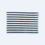 A rectangular fabric item with horizontal navy blue and off-white stripes, laid flat against a very light blue background.