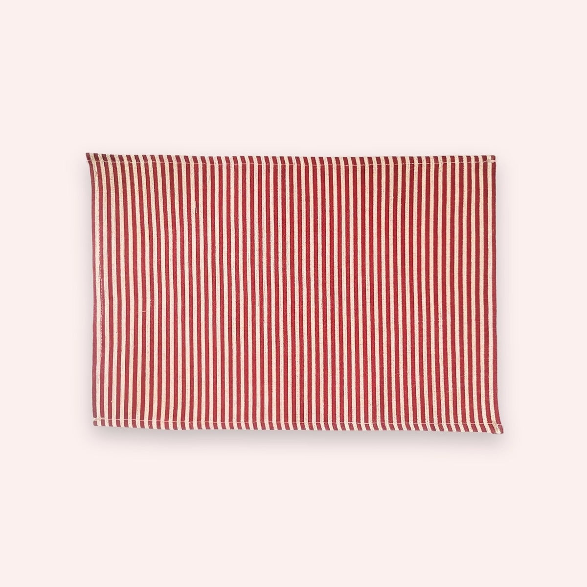Red and cream narrow-stripe cotton linen placemat, 11.8 x 15.7 in (30 x 40 cm), on a soft blush backdrop