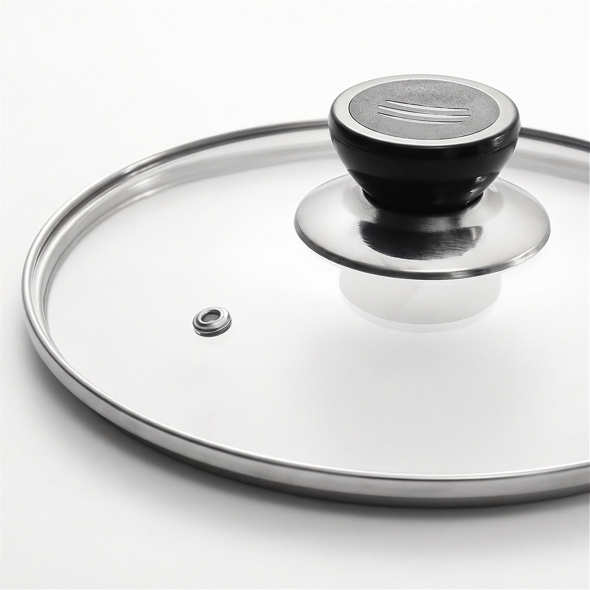 A clear glass lid with a polished silver metal rim and a black plastic handle, shown on a clean white background.