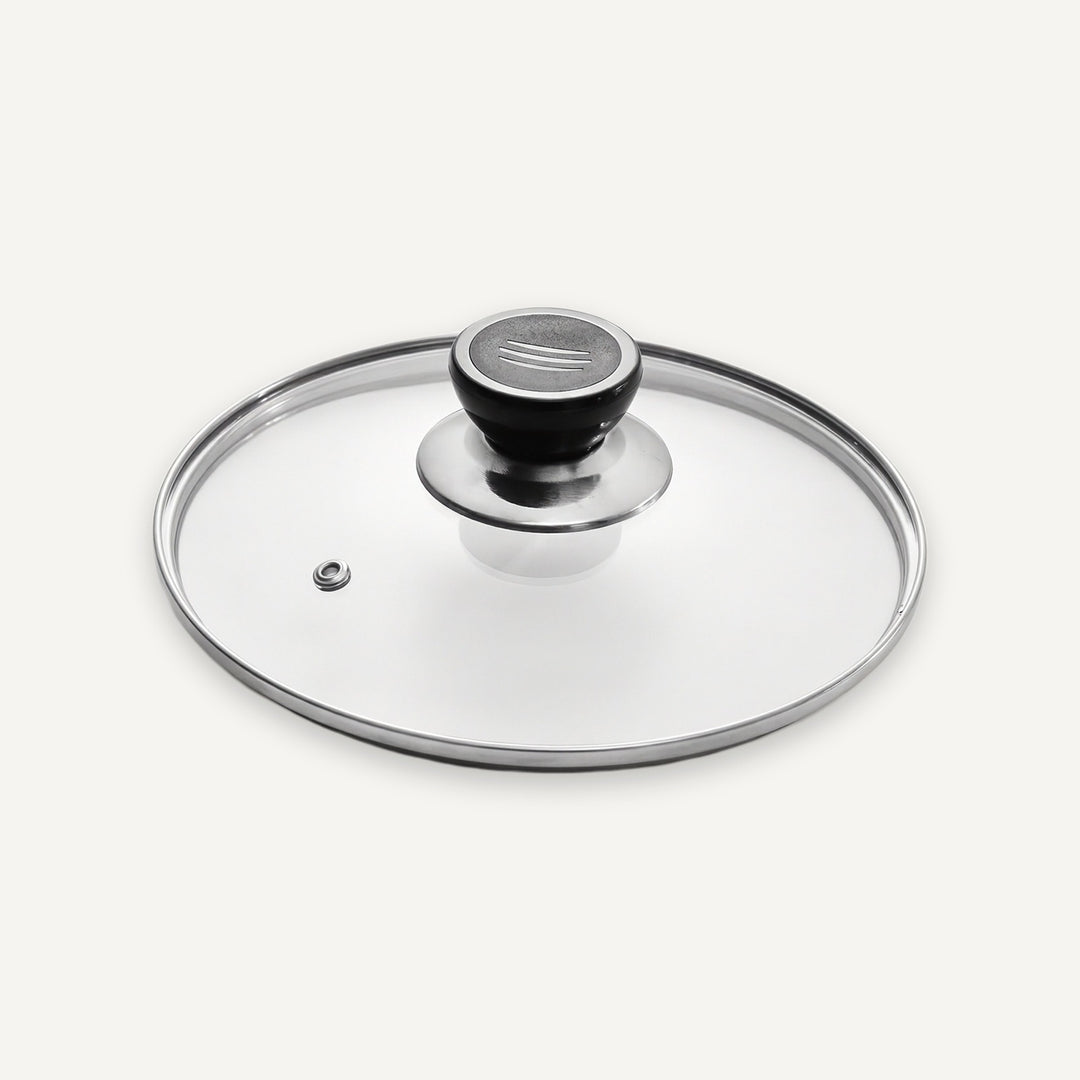 A clear glass lid with a polished silver metal rim and a black knob, photographed on a clean off-white background.