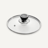 A clear glass lid with a polished silver metal rim and a black knob, photographed on a clean off-white background.