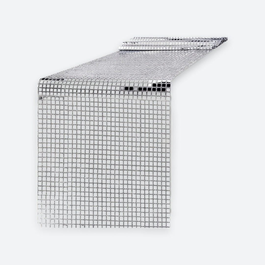 A silver disco ball mesh table runner with a reflective grid pattern, shown partially unrolled on a light gray background.