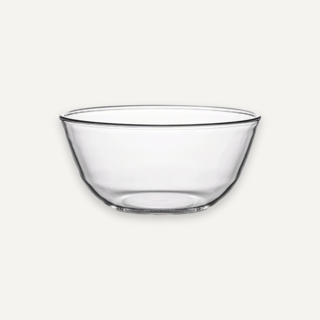 A clear glass mixing bowl with a wide rim and slightly tapered base, shown on a plain light gray background.